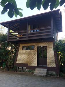 a house with a balcony on top of it at Zululand Bangalôs in Guarda do Embaú