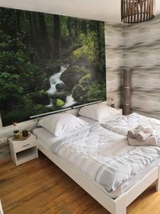 a bedroom with a bed with a painting of a river at Zur Linde in Mainzweiler