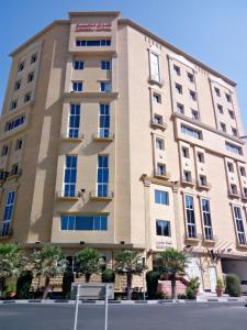 a tall building with a sign in front of it at Asherij Hotel in Doha