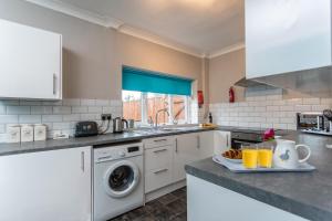 uma cozinha com um lavatório e uma máquina de lavar roupa em James Cook Accommodation em Middlesbrough