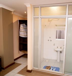 a bathroom with a shower and a sink at Lagos Hotel in Nairobi
