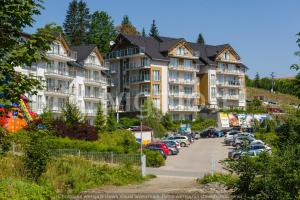 eine Reihe von Apartmenthäusern auf einem Parkplatz in der Unterkunft Apartament Czarna Góra Sienna LIV in Heudorf