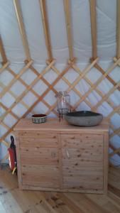 a wooden dresser with a tub in a yurt at La Yourte de la Ferme Froidefontaine in Havelange