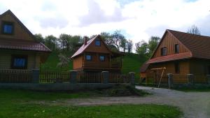 Deux maisons en bois avec une clôture devant elles dans l'établissement Drevenica Silvia, à Liptovský Mikuláš