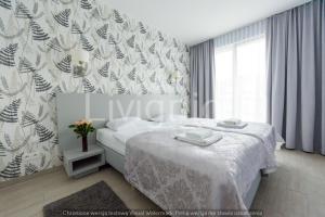 ein Schlafzimmer mit einem weißen Bett und einem Fenster in der Unterkunft Apartament Czarna Góra Sienna LIV in Heudorf