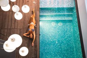 a man laying on the floor next to a swimming pool at 1926 Le Soleil Hotel & Spa in Sliema