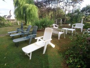 a group of chairs sitting in the grass at La Mare aux 3 Diables in Fresney-le-Vieux