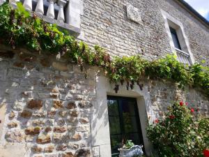a stone building with plants on the side of it at La Mare aux 3 Diables in Fresney-le-Vieux