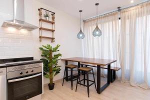 a kitchen with a wooden table and a table and a stove at NEW GRAN ESTUDIO A ESTRENAR CENTRO de MADRID in Madrid