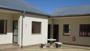 a building with a table in front of it at Villa Strada Guesthouse in Klerksdorp