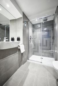 a bathroom with a shower and a tub and a sink at Roomzzz York City in York