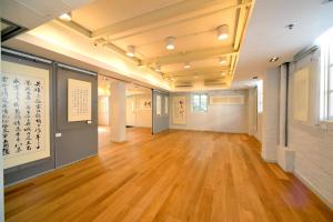 a large room with wooden floors and paintings on the walls at 饒宗頤文化館 - 翠雅山房 in Hong Kong