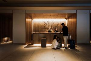 um grupo de pessoas em pé em um lobby em ONSEN RYOKAN Yuen Sapporo em Sapporo