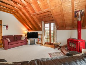 a living room with a fireplace and a red couch at Flora's Barn in Taunton