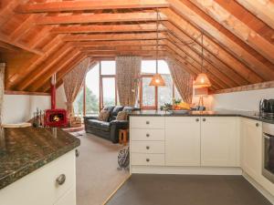 an open kitchen and living room with a couch at Flora's Barn in Taunton