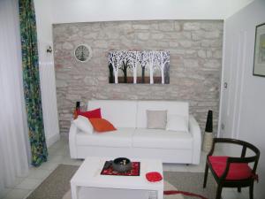 a living room with a white couch and a stone wall at Villa Maria Callas Sirmione in Sirmione +44 photos