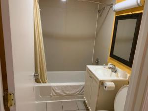 a bathroom with a tub and a sink and a shower at Scottish Inns Wrightstown in Wrightstown