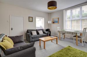 a living room with a couch and a table at The Courtyard Cirencester in Cirencester