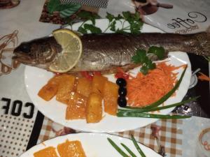 een bord voedsel met vis en groenten bij Cottage 5 in Karpaten