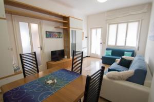 sala de estar con mesa y sofá azul en Grande BILOCALE con GIARDINO e POSTO AUTO PRIVATO Comodo al mare en Varazze