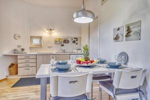 een eetkamer met een witte tafel en stoelen bij Zentral gelegenes Apartment mit Garage & kleinem Außenbereich in Caldaro