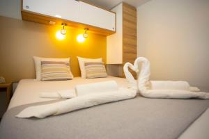 Una cama con un cisne hecho de toallas en Mobile Home Baško Polje TBMrent, en Baška Voda