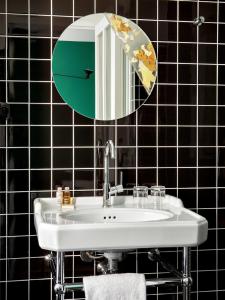 a bathroom with a white sink and a mirror at New Hotel Le Voltaire in Paris