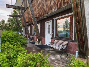 a bench sitting on the porch of a building at Kartano Kievari in Äänekoski