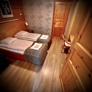アーネコスキにあるKartano Kievariのベッド2台、デスクが備わる小さな客室です。
