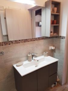 een badkamer met een witte wastafel en een spiegel bij LA PICCOLA DEPENDANCE in Tuscania