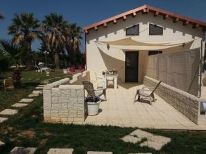 un patio con 2 sillas y una mesa frente a una casa en Casa Vacanza al Mare Villa Adriana, en Granelli