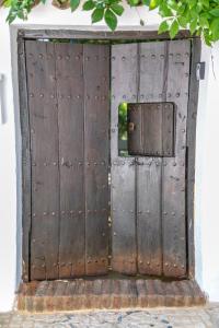 una antigua puerta de madera con una ventana en un edificio en Casita Collado 3, en Alájar