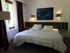1 dormitorio con 1 cama blanca grande y 2 almohadas en La maison de Cécile, en Ventron