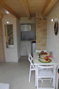 una mesa blanca con un plato de comida en la cocina en Casa Vacanza al Mare Villa Adriana, en Granelli
