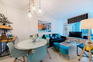 un soggiorno con tavolo e sedie blu di 2 Room Condo - 5 mins from Costa da Caparica Beach & Bars a Costa da Caparica