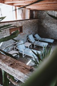 eine Terrasse mit Stühlen, Tischen und Ziegelwand in der Unterkunft Hotel Grischuna in Bivio