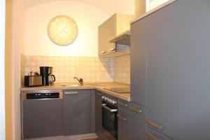 een keuken met een wastafel en een klok aan de muur bij Ferienwohnung Altstadt in Annaberg-Buchholz