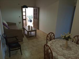 a dining room with a table and a table and chairs at Buganvilla Sea View apts in Agia Pelagia