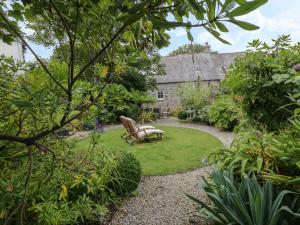 a garden with a bench in front of a building at Fairfield Cottage in Boscastle