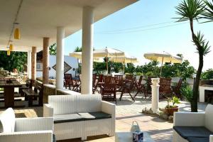 an outdoor patio with chairs and tables and umbrellas at Villa Grazia in Capo Vaticano