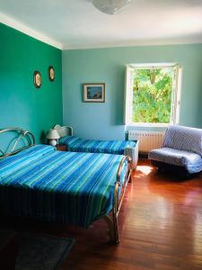 a bedroom with two beds and a chair and a window at I POGGI DI S.CATERINA in Sarzana +26 photos