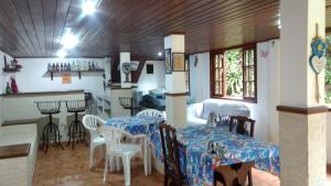a living room with tables and chairs and a kitchen at Sítio Canto das Águas in Marechal Floriano