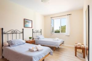 a bedroom with two beds and a window at Villa Juaneda in Ciutadella