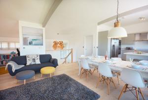 a living room with a dining table and a kitchen at Sundown in Bude