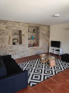 a living room with a couch and a table at Casa do Pomarelho in Póvoa de Lanhoso