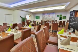 a restaurant with tables and chairs and a chalkboard at Hotel zur Pfalz in Kandel