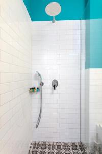 a bathroom with a shower with white tiles at Kouros Hill in Xirokástellon