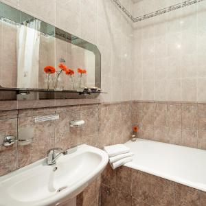 a bathroom with a sink and a bath tub at Khreschatyk Suites in Kyiv