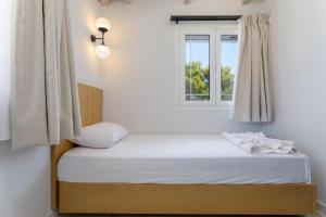 a bed in a room with a window at Kouros Hill in Xirokástellon