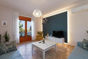 sala de estar con sofá y mesa en Sea La Vie house, close to the beach, By ThinkVilla en Panormos Rethymno
